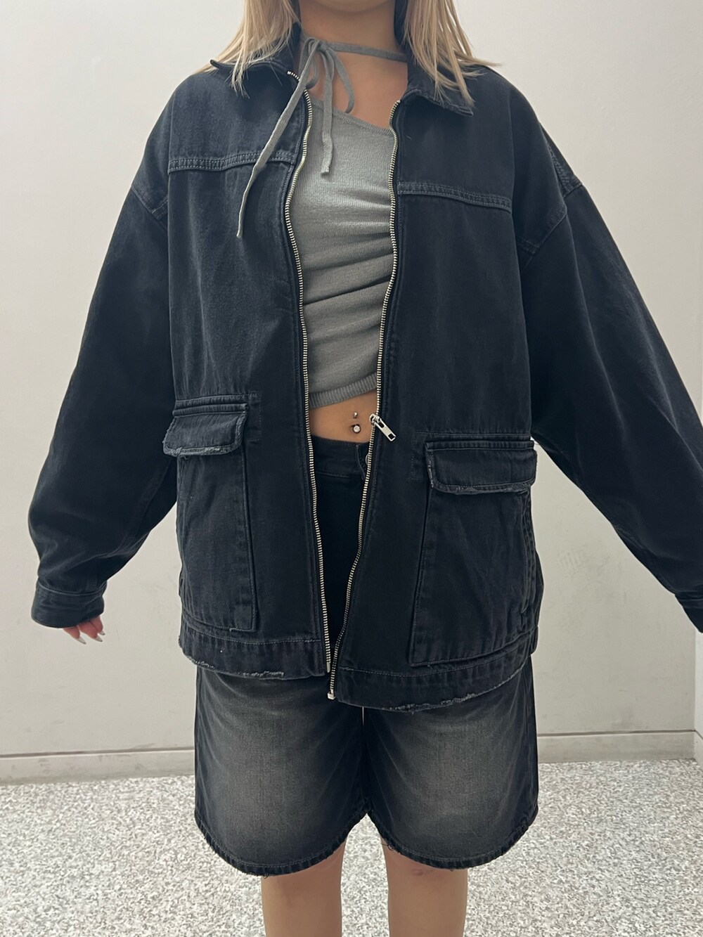 ブラック系のブルゾン、ブラック系のデニムパンツ、グレー系のニット/セーターを着用したレディースの冬コーディネートの4枚目の写真