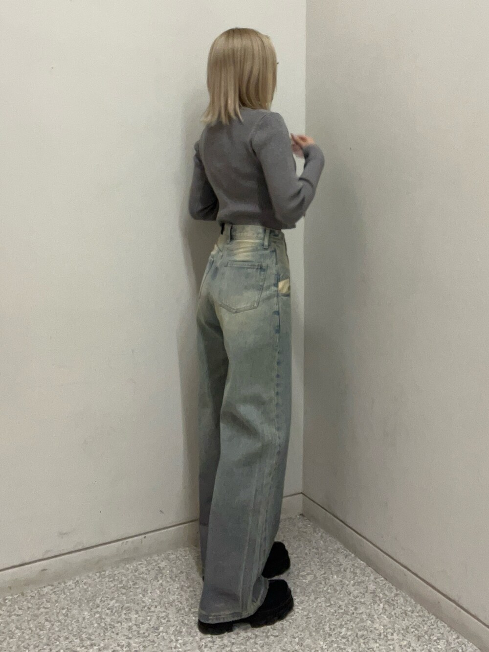 ブルー系のデニムパンツ、シルバー系のニット/セーター、ブラック系のブーツを着用したレディースの冬コーディネートの2枚目の写真