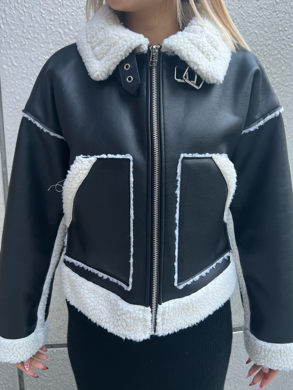 ブラック系のブルゾン、ブラック系のスカート、ブラック系のブーツを着用したレディースの冬コーディネートの4枚目の写真