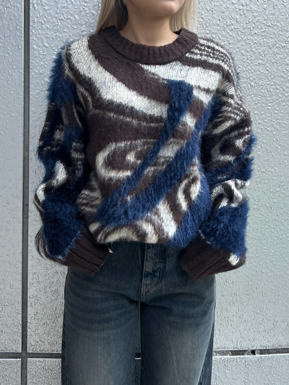 ブラウン系のニット/セーター、ブルー系のデニムパンツ、ブラック系のブーツを着用したレディースの冬コーディネートの4枚目の写真