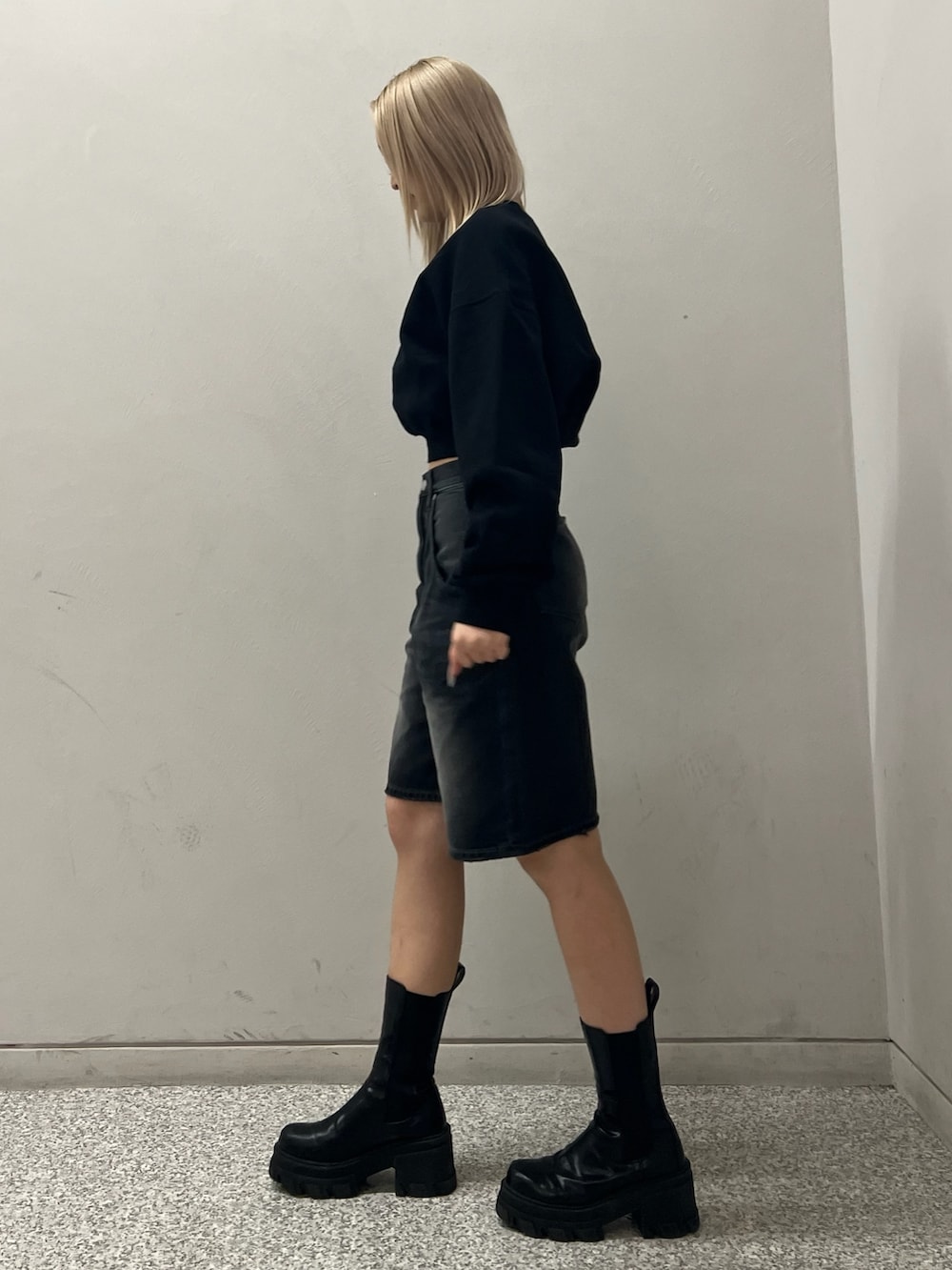 ブラック系のデニムパンツ、ブラック系のブーツ、ブラック系のTシャツ/カットソーを着用したレディースの冬コーディネートの2枚目の写真