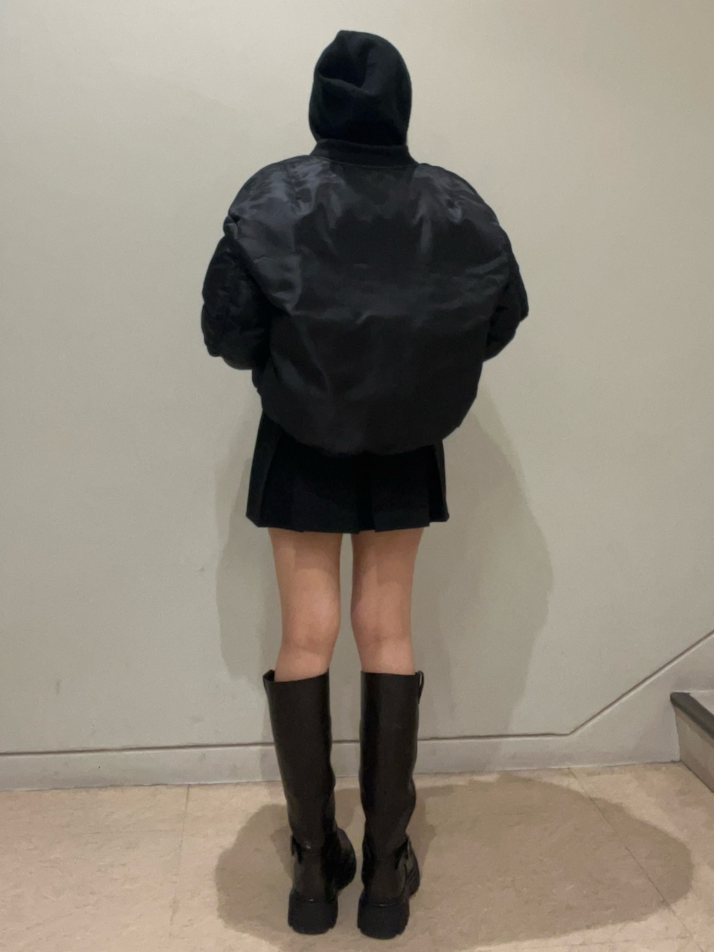 ブラック系のブルゾン、ブラック系のニット/セーター、ブラック系のスカートを着用したレディースの秋コーディネートの3枚目の写真