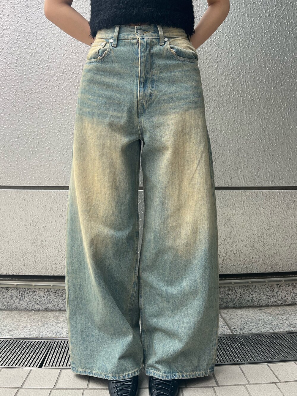 ブラック系のニット/セーター、ブルー系のデニムパンツ、ブラック系のパンプスを着用したレディースの春コーディネートの4枚目の写真