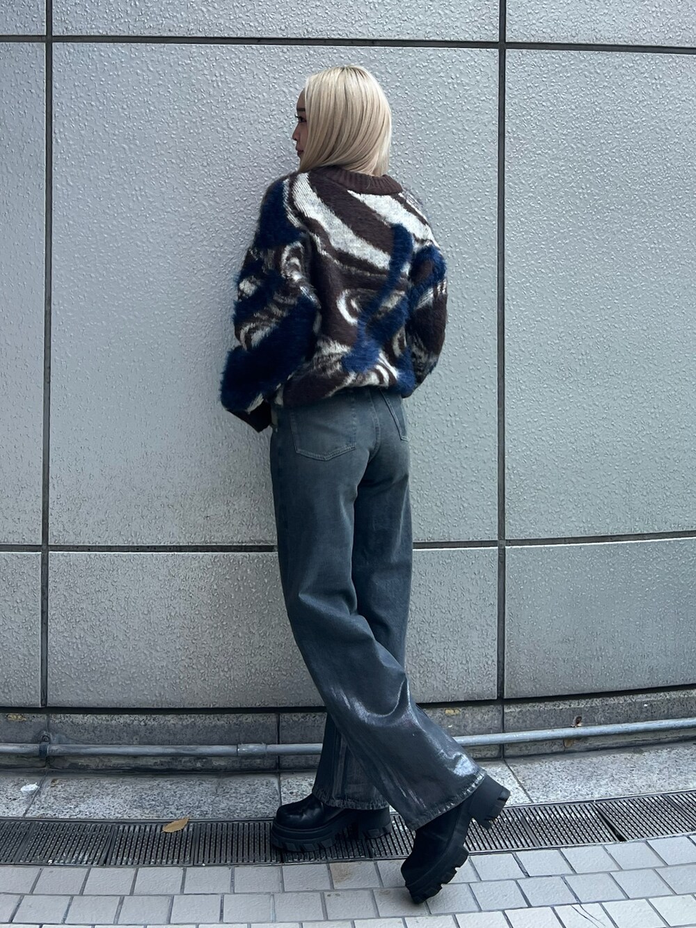 ブラウン系のニット/セーター、ブルー系のデニムパンツ、ブラック系のブーツを着用したレディースの冬コーディネートの2枚目の写真