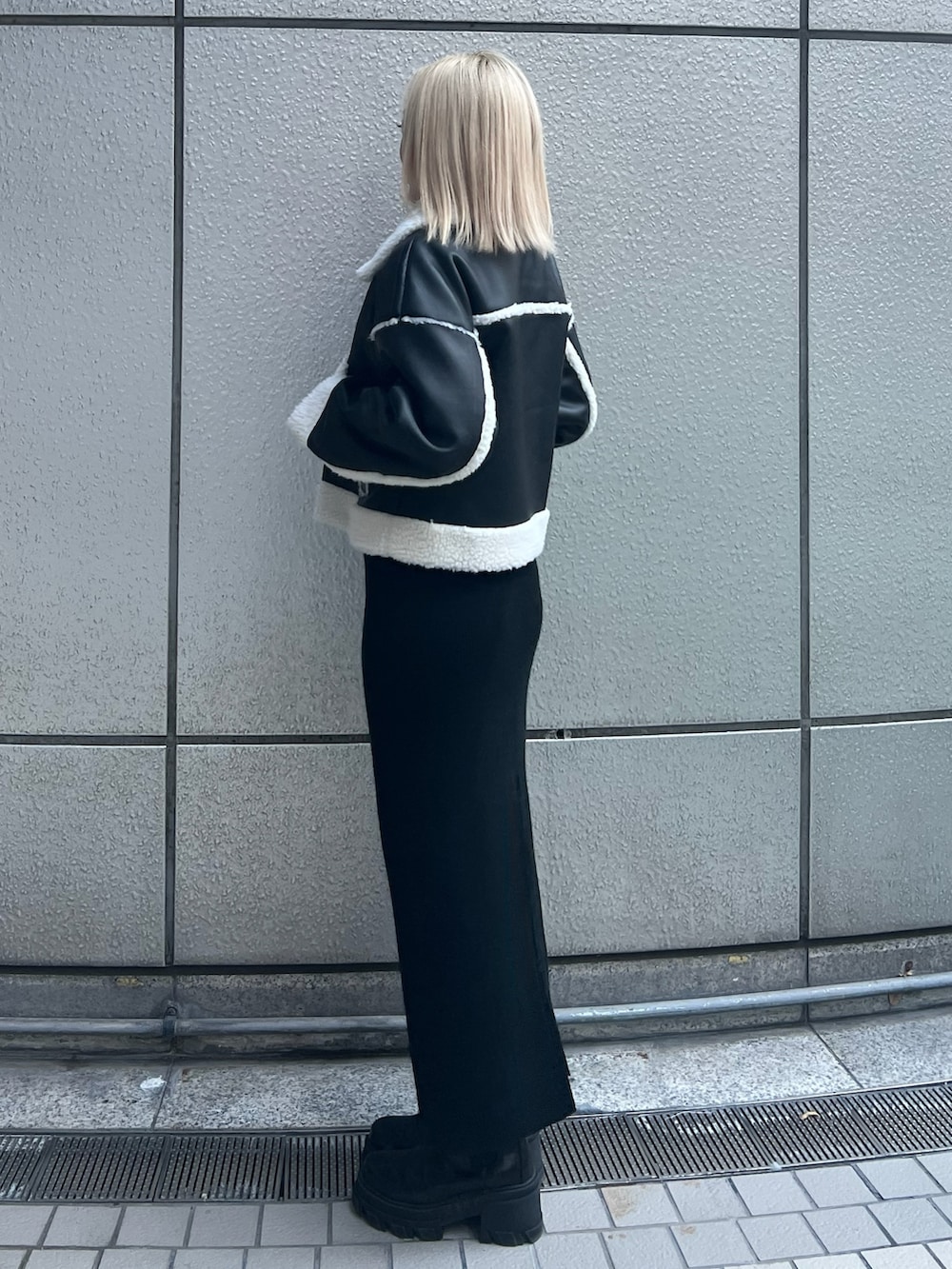 ブラック系のブルゾン、ブラック系のスカート、ブラック系のブーツを着用したレディースの冬コーディネートの2枚目の写真