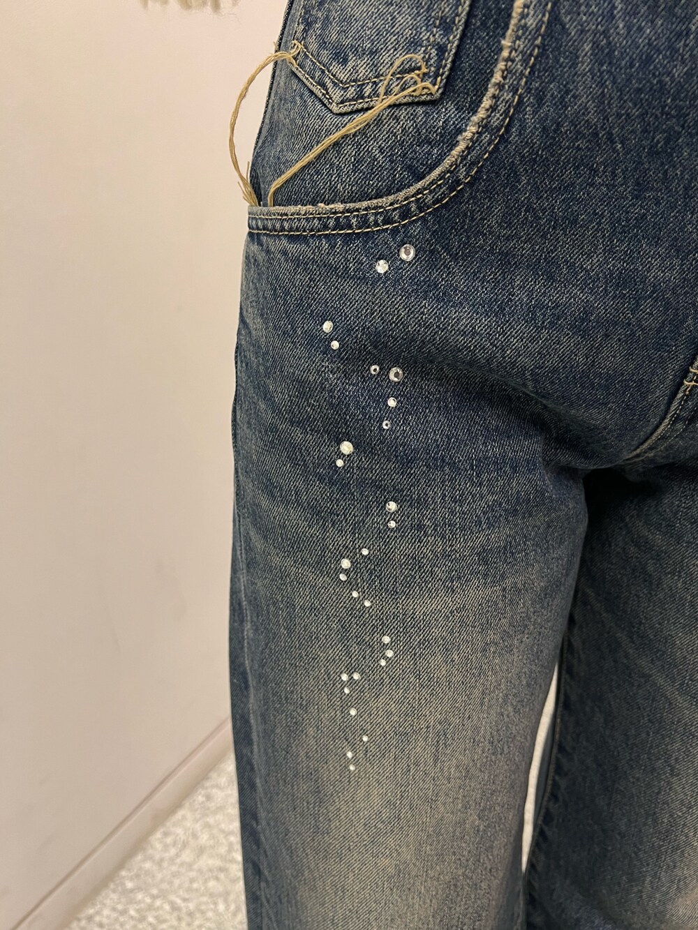 ブルー系のデニムパンツ、ブラック系のブーツ、ホワイト系のニット/セーターを着用したレディースの秋コーディネートの5枚目の写真