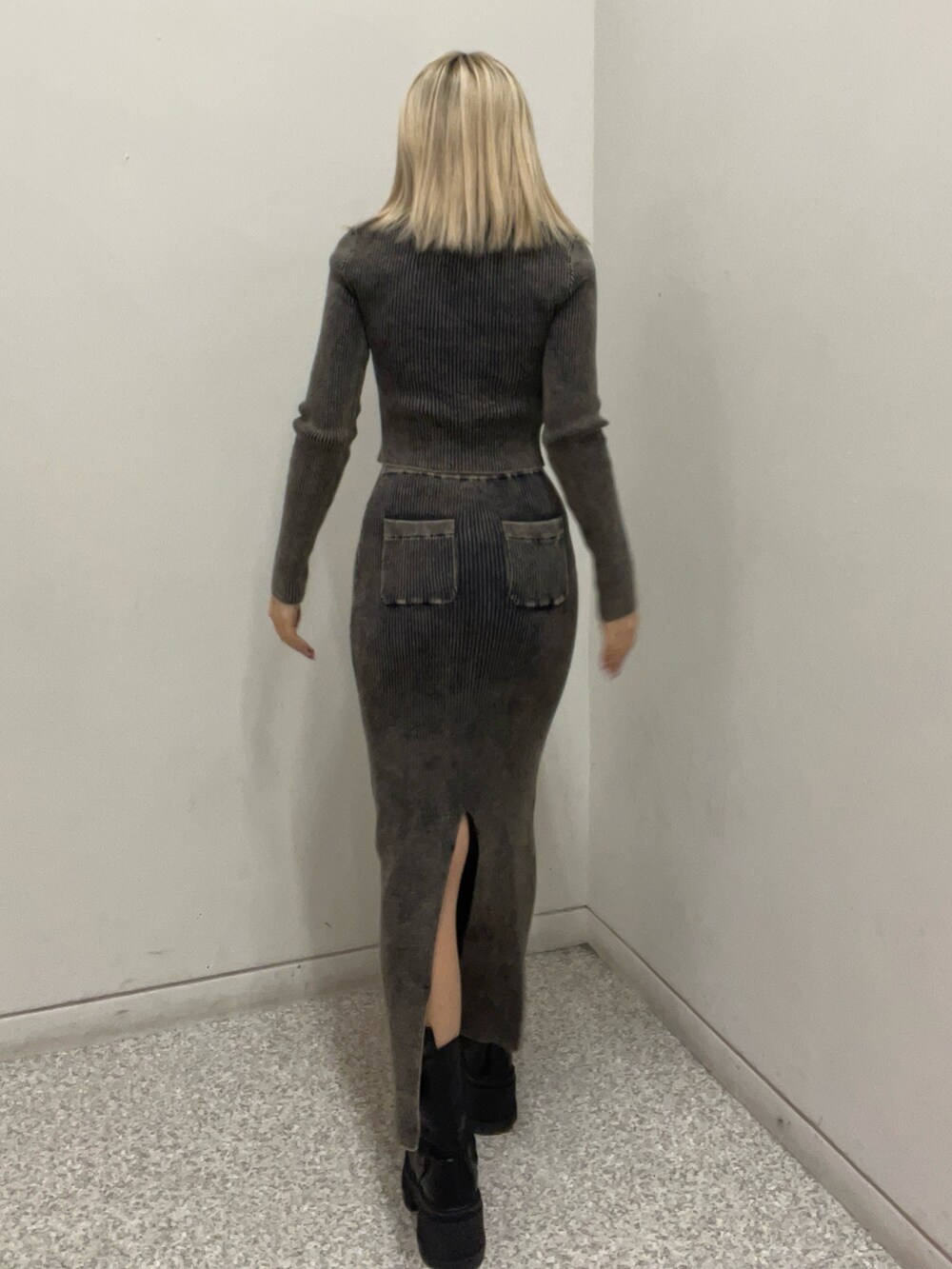 ブラック系のニット/セーター、ブラック系のスカート、ブラック系のブーツを着用したレディースの冬コーディネートの3枚目の写真