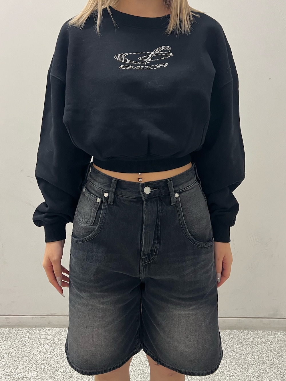 ブラック系のデニムパンツ、ブラック系のブーツ、ブラック系のTシャツ/カットソーを着用したレディースの冬コーディネートの4枚目の写真