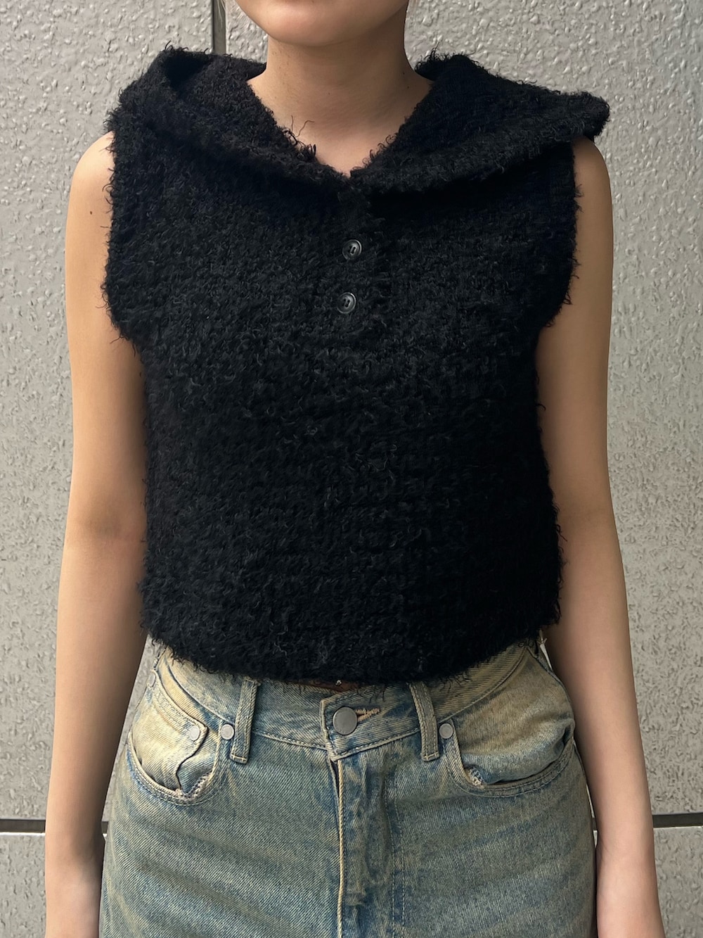 ブラック系のニット/セーター、ブルー系のデニムパンツ、ブラック系のパンプスを着用したレディースの春コーディネートの5枚目の写真