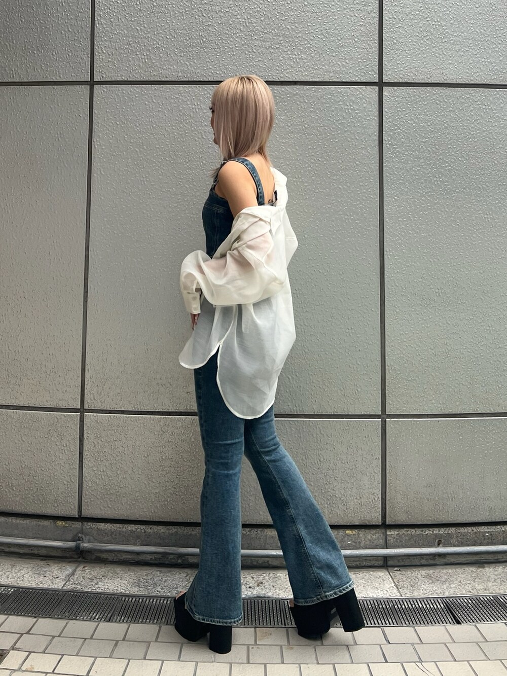 ブルー系のサロペット/オーバーオール、ブラック系のサンダル、ホワイト系のシャツ/ブラウスを着用したレディースの春コーディネートの3枚目の写真