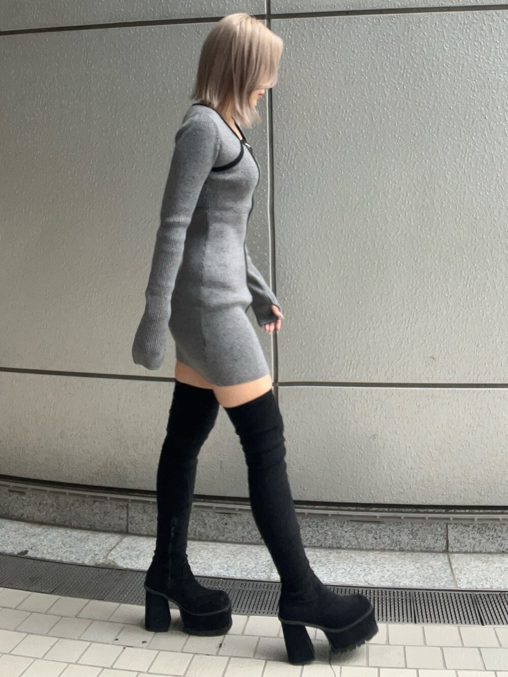グレー系のワンピース、ブラック系のブーツを着用したレディースの秋コーディネートの3枚目の写真