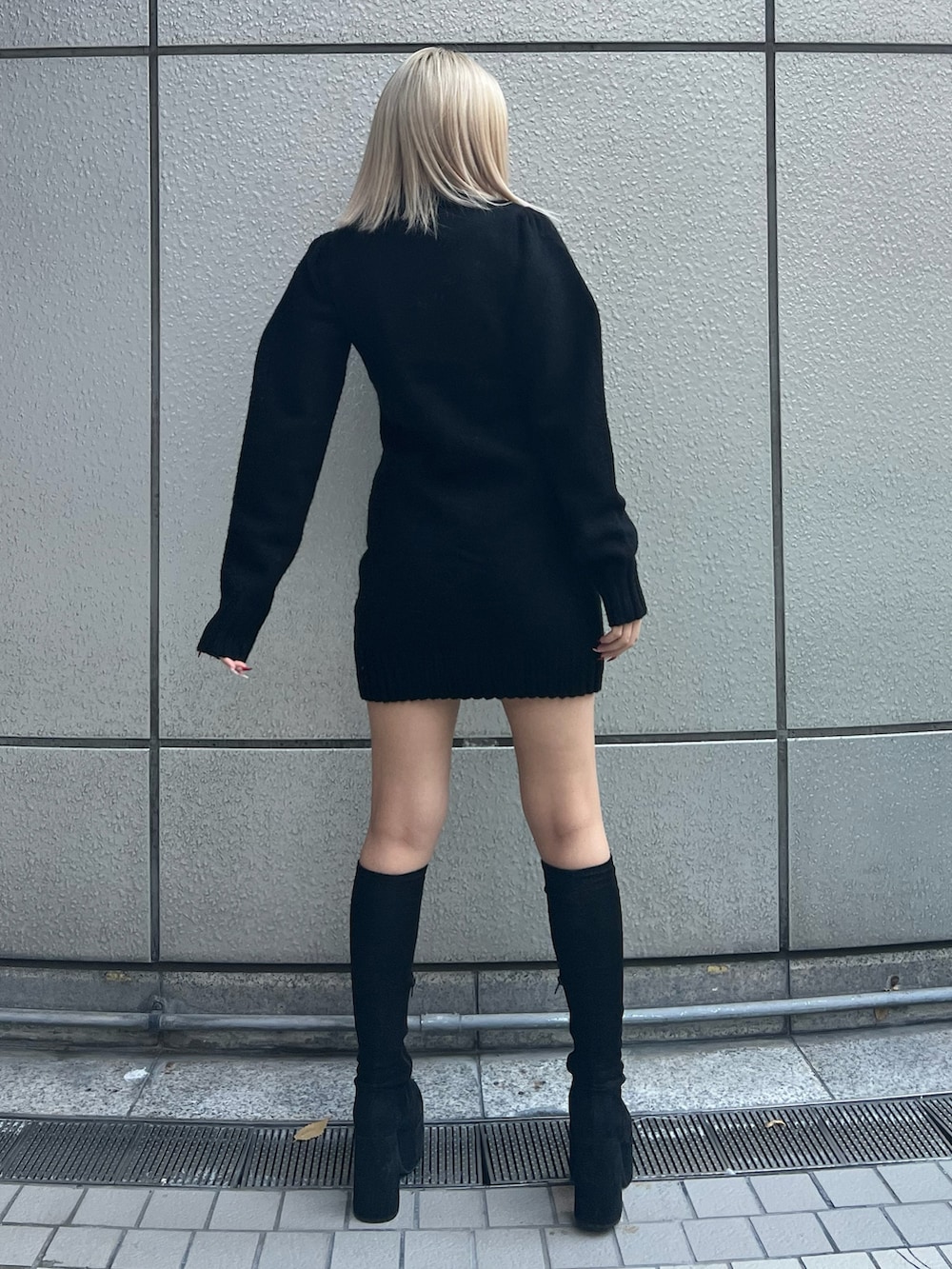 ブラック系のワンピース、その他のブーツを着用したレディースの冬コーディネートの2枚目の写真