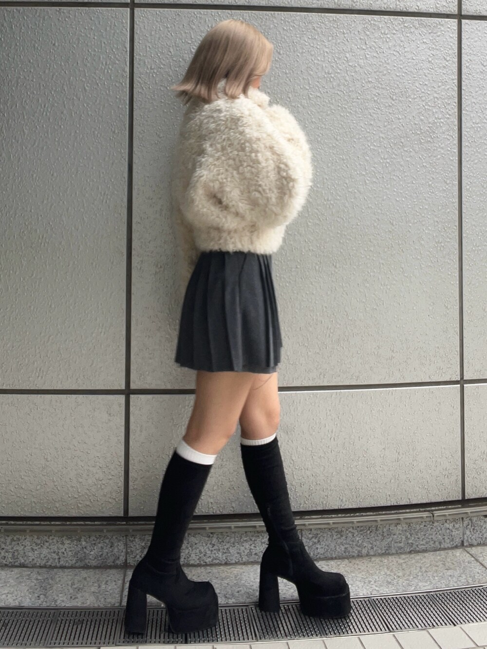 ホワイト系のブルゾン、グレー系のスカート、その他のブーツを着用したレディースの秋コーディネートの2枚目の写真