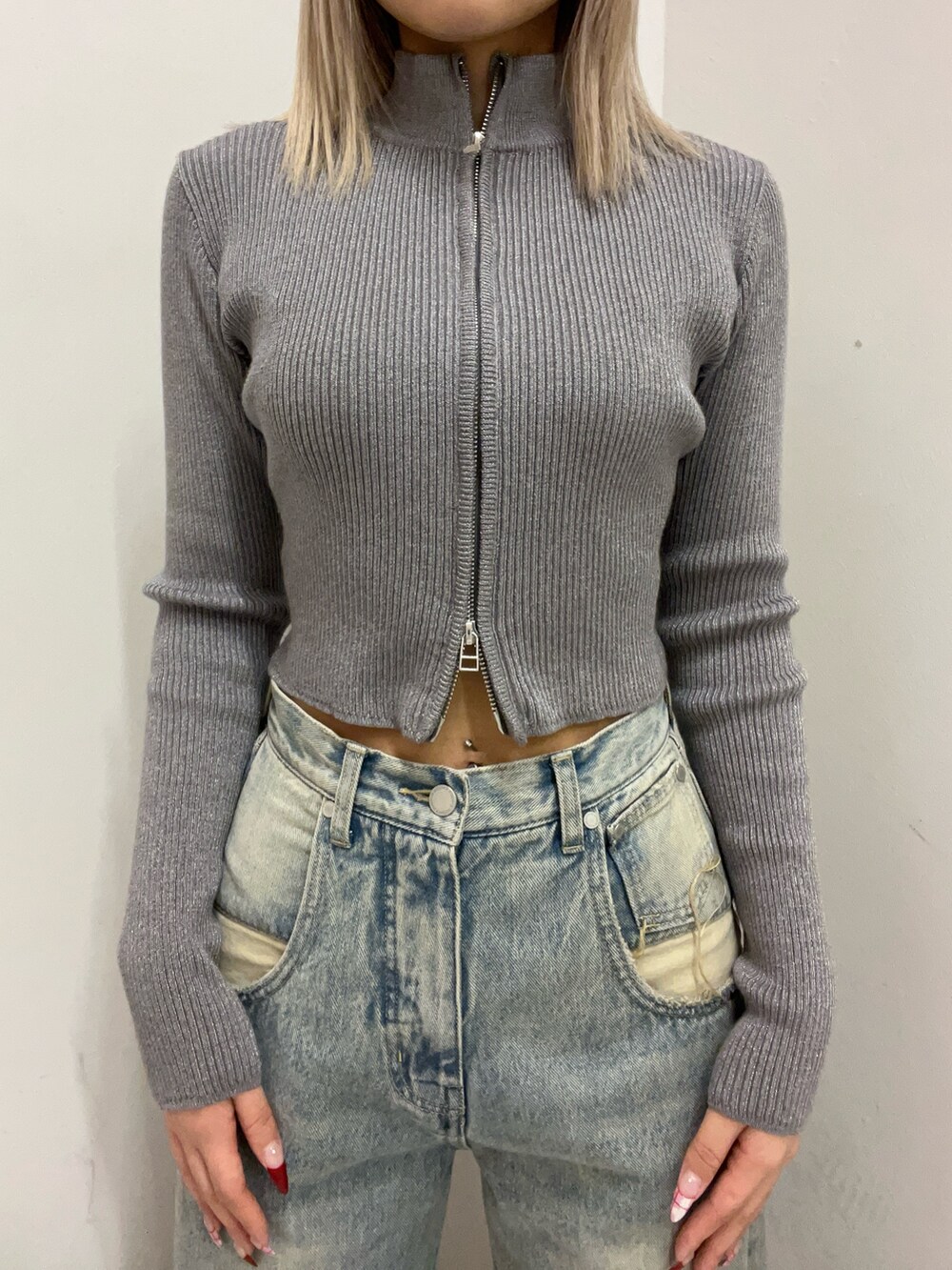 ブルー系のデニムパンツ、シルバー系のニット/セーター、ブラック系のブーツを着用したレディースの冬コーディネートの4枚目の写真