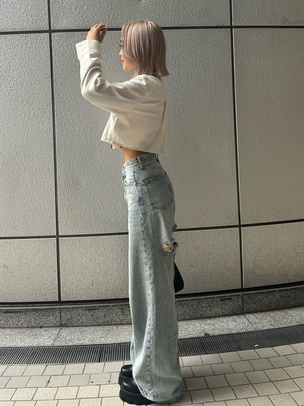 ブルー系のデニムパンツ、ホワイト系のシャツ/ブラウス、ブラック系のブーツを着用したレディースの秋コーディネートの2枚目の写真