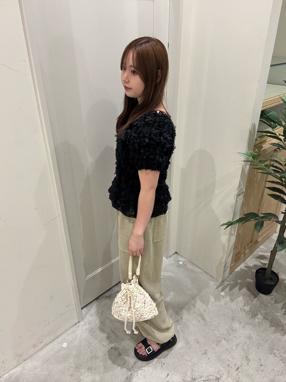 ブラック系のシャツ/ブラウス、ホワイト系のショルダーバッグ、ベージュ系のスウェットパンツを着用したレディースの夏コーディネートの3枚目の写真