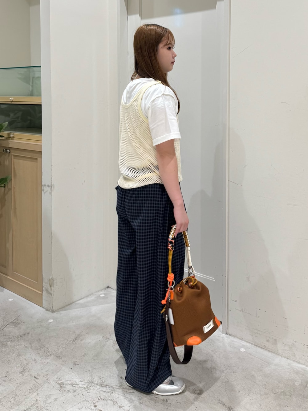 ブルー系のその他パンツ、イエロー系のショルダーバッグ、ホワイト系のタンクトップを着用したレディースの夏コーディネートの6枚目の写真