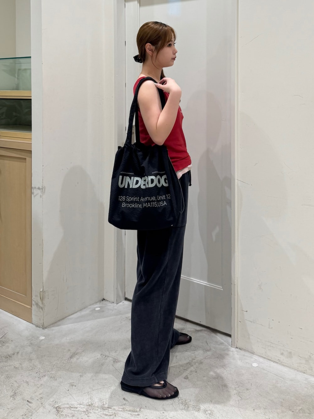 ブラック系のスウェットパンツ、レッド系のタンクトップ、ブラック系のトートバッグを着用したレディースの夏コーディネートの4枚目の写真