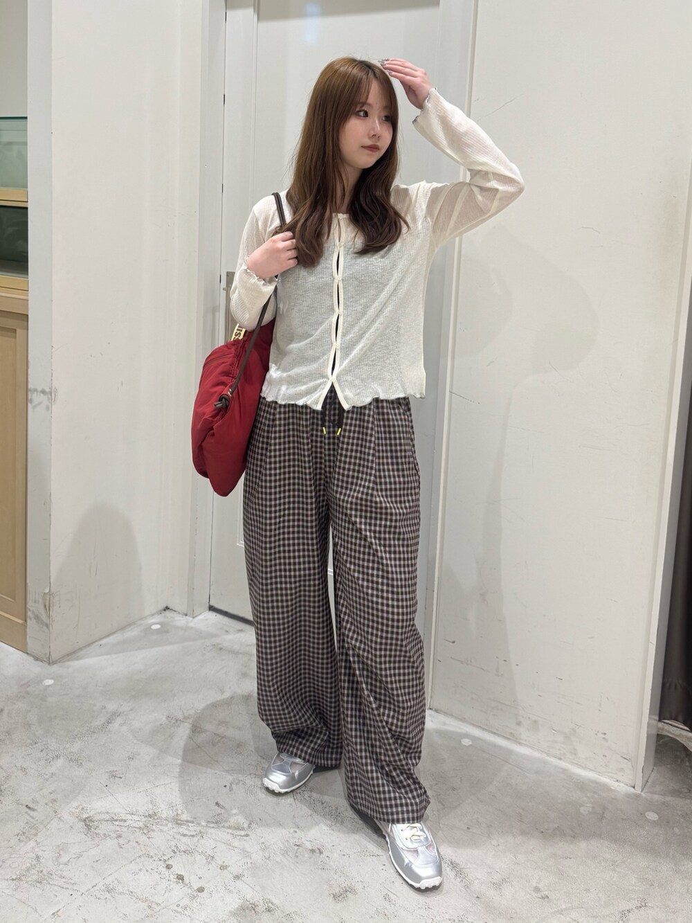 ホワイト系のカーディガン/ボレロ、レッド系のバックパック/リュック、ブラウン系のその他パンツを着用したレディースの夏コーディネートの3枚目の写真