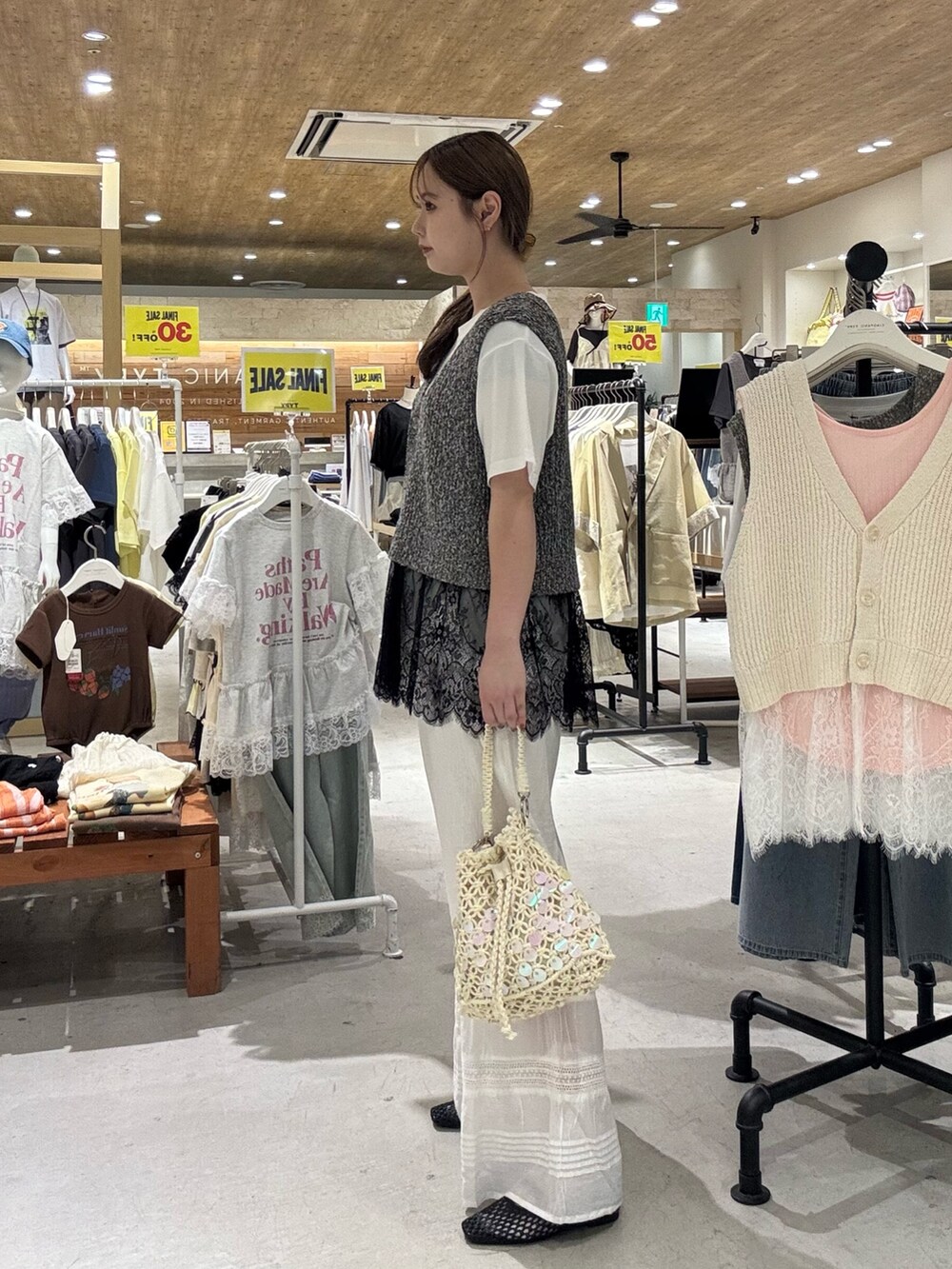 ブラック系のベスト、ホワイト系のショルダーバッグ、ホワイト系のTシャツ/カットソーを着用したレディースの夏コーディネートの4枚目の写真