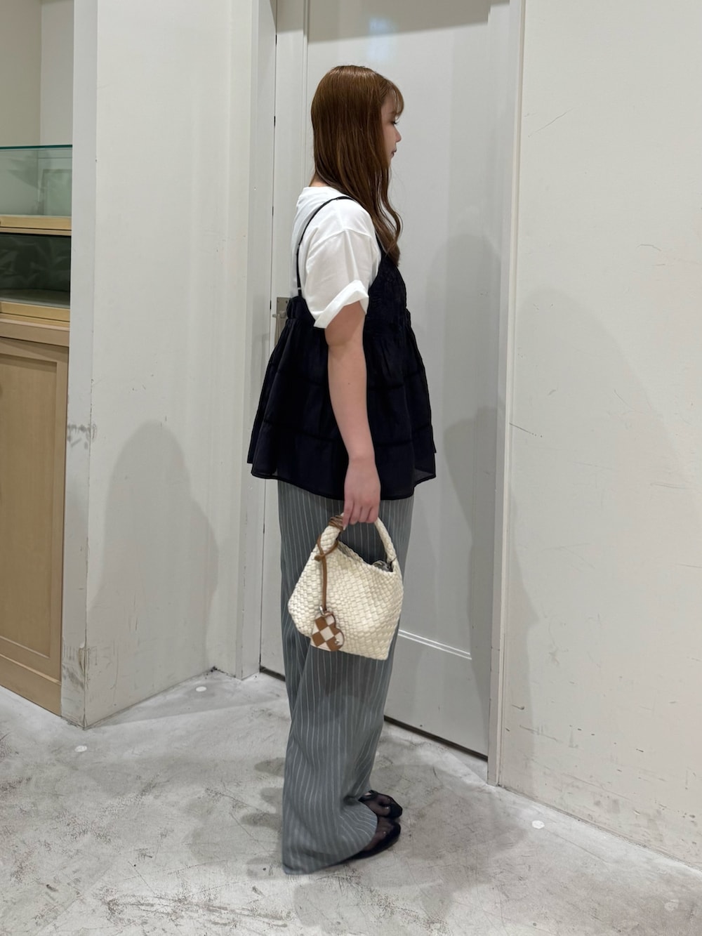 グレー系のその他パンツ、ホワイト系のショルダーバッグ、ブラック系のシャツ/ブラウスを着用したレディースの夏コーディネートの4枚目の写真