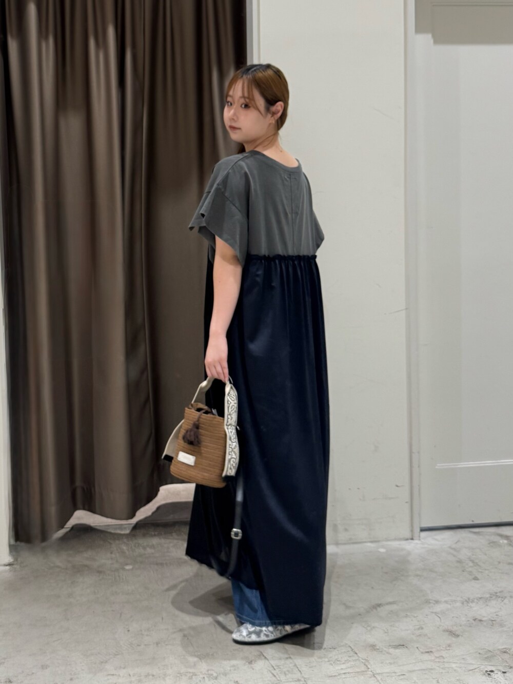 ブラウン系のトートバッグ、ホワイト系のパンプス、ブルー系のデニムパンツを着用したレディースの夏コーディネートの3枚目の写真