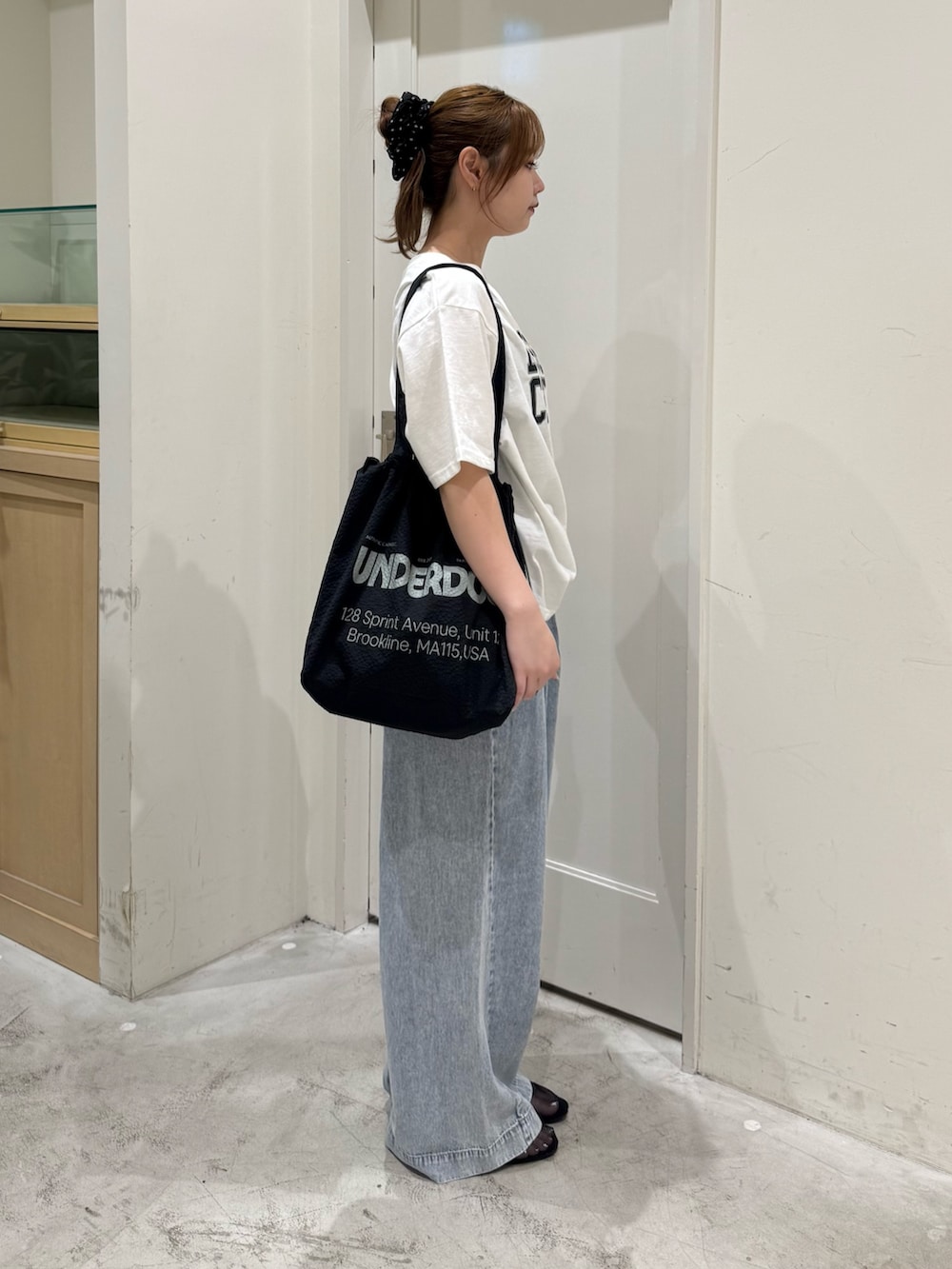 ブルー系のデニムパンツ、ホワイト系のTシャツ/カットソー、ブラック系のトートバッグを着用したレディースの夏コーディネートの6枚目の写真