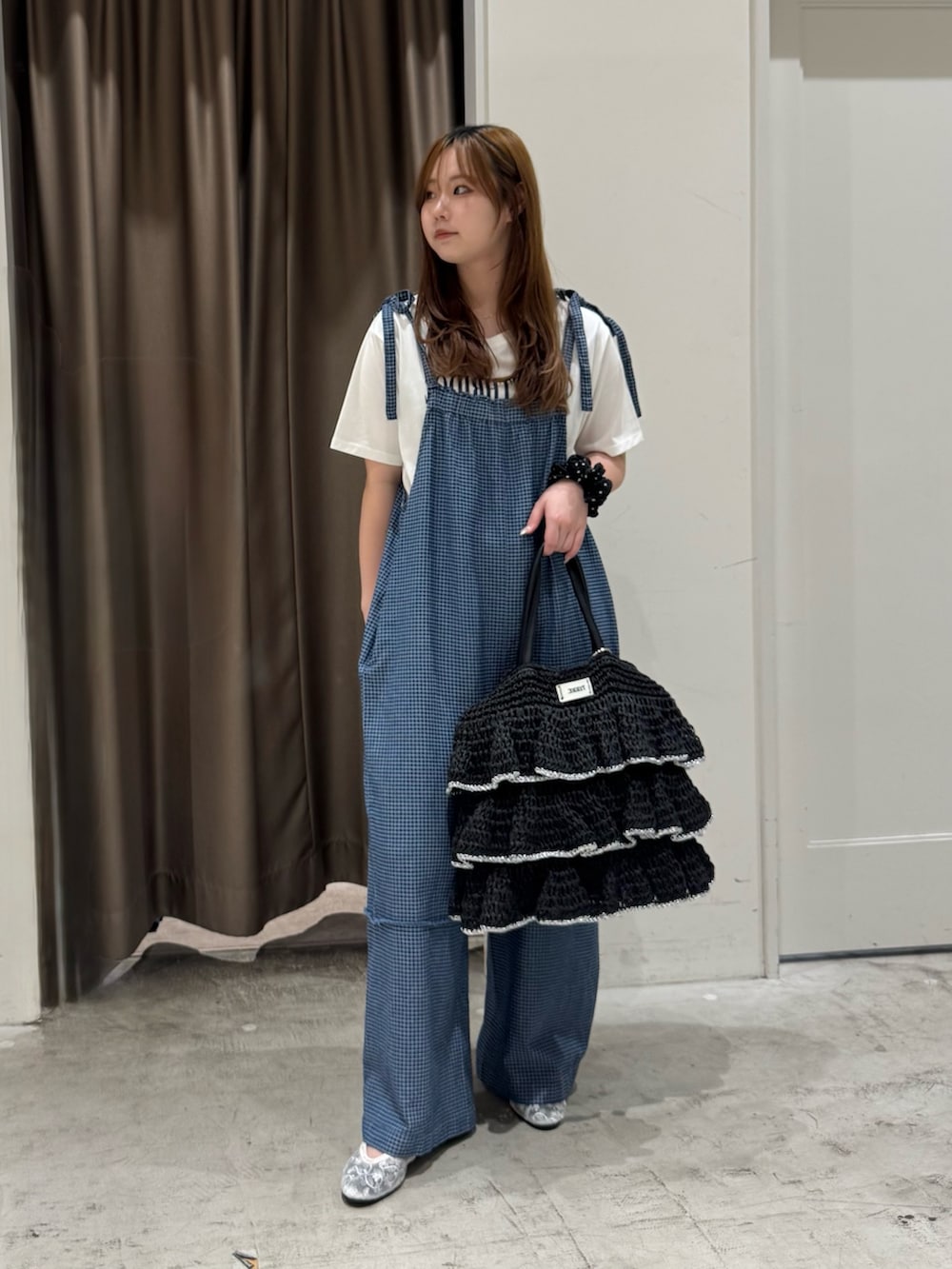 ブルー系のサロペット/オーバーオール、ブラック系のトートバッグ、ホワイト系のTシャツ/カットソーを着用したレディースの夏コーディネートの2枚目の写真