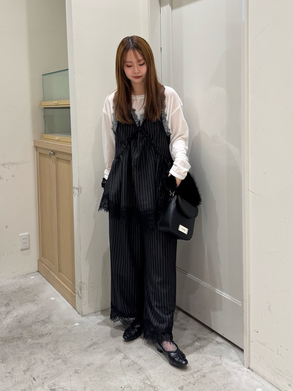 ブラック系のチュニック、ホワイト系のTシャツ/カットソー、ブラック系のショルダーバッグを着用したレディースの秋コーディネートの3枚目の写真