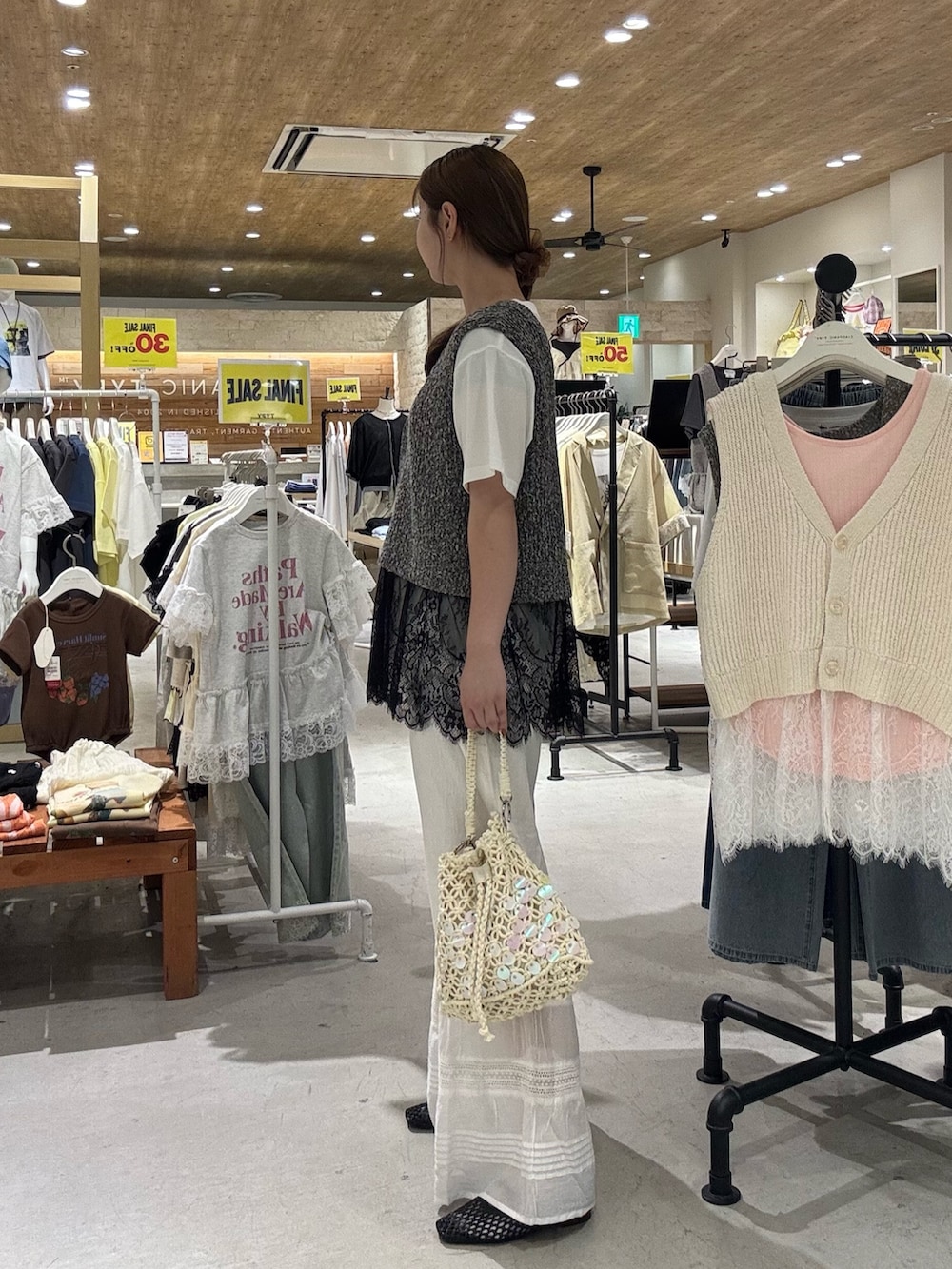 ブラック系のベスト、ホワイト系のショルダーバッグ、ホワイト系のTシャツ/カットソーを着用したレディースの夏コーディネートの3枚目の写真