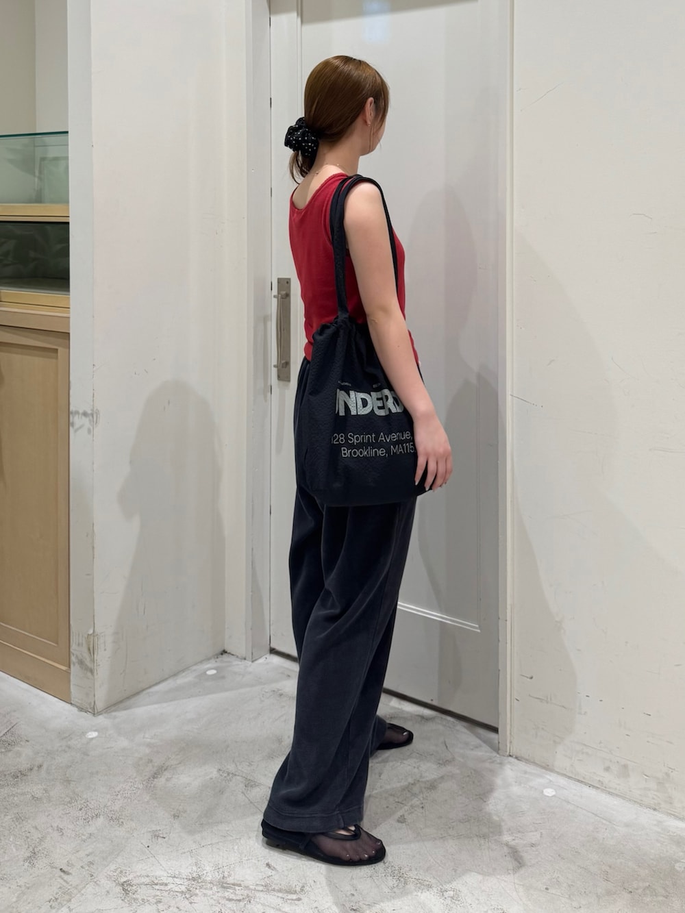 ブラック系のスウェットパンツ、レッド系のタンクトップ、ブラック系のトートバッグを着用したレディースの夏コーディネートの5枚目の写真