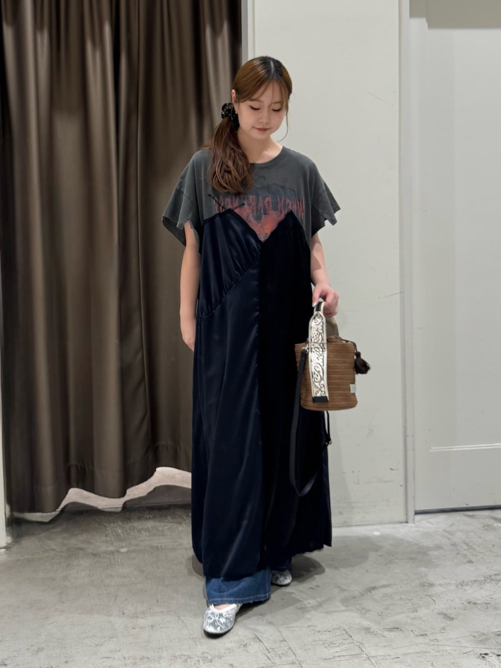 ブラウン系のトートバッグ、ホワイト系のパンプス、ブルー系のデニムパンツを着用したレディースの夏コーディネートの2枚目の写真