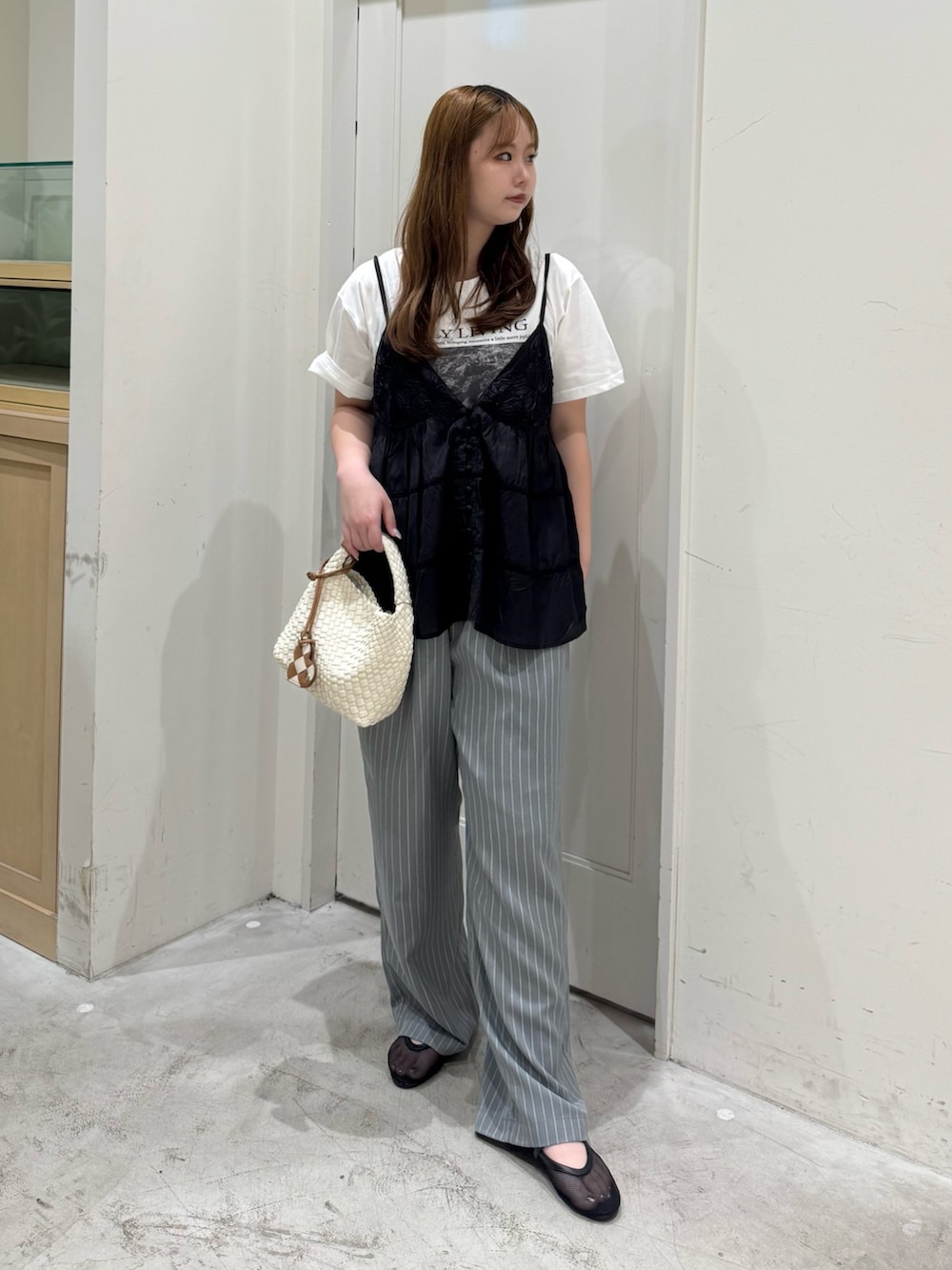 グレー系のその他パンツ、ホワイト系のショルダーバッグ、ブラック系のシャツ/ブラウスを着用したレディースの夏コーディネートの2枚目の写真