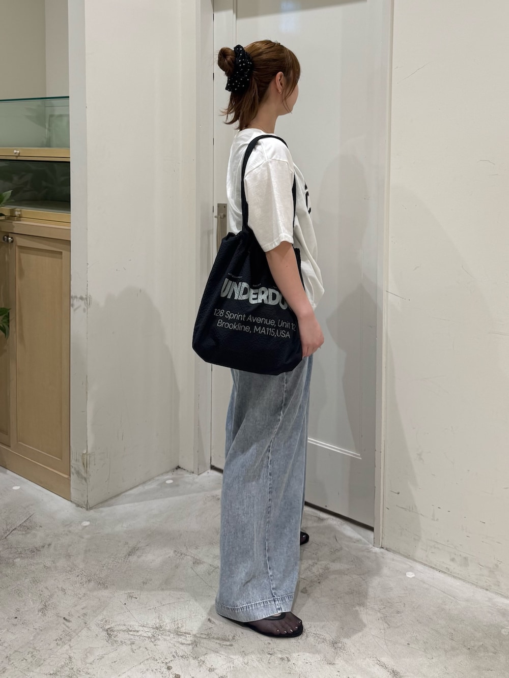 ブルー系のデニムパンツ、ホワイト系のTシャツ/カットソー、ブラック系のトートバッグを着用したレディースの夏コーディネートの5枚目の写真