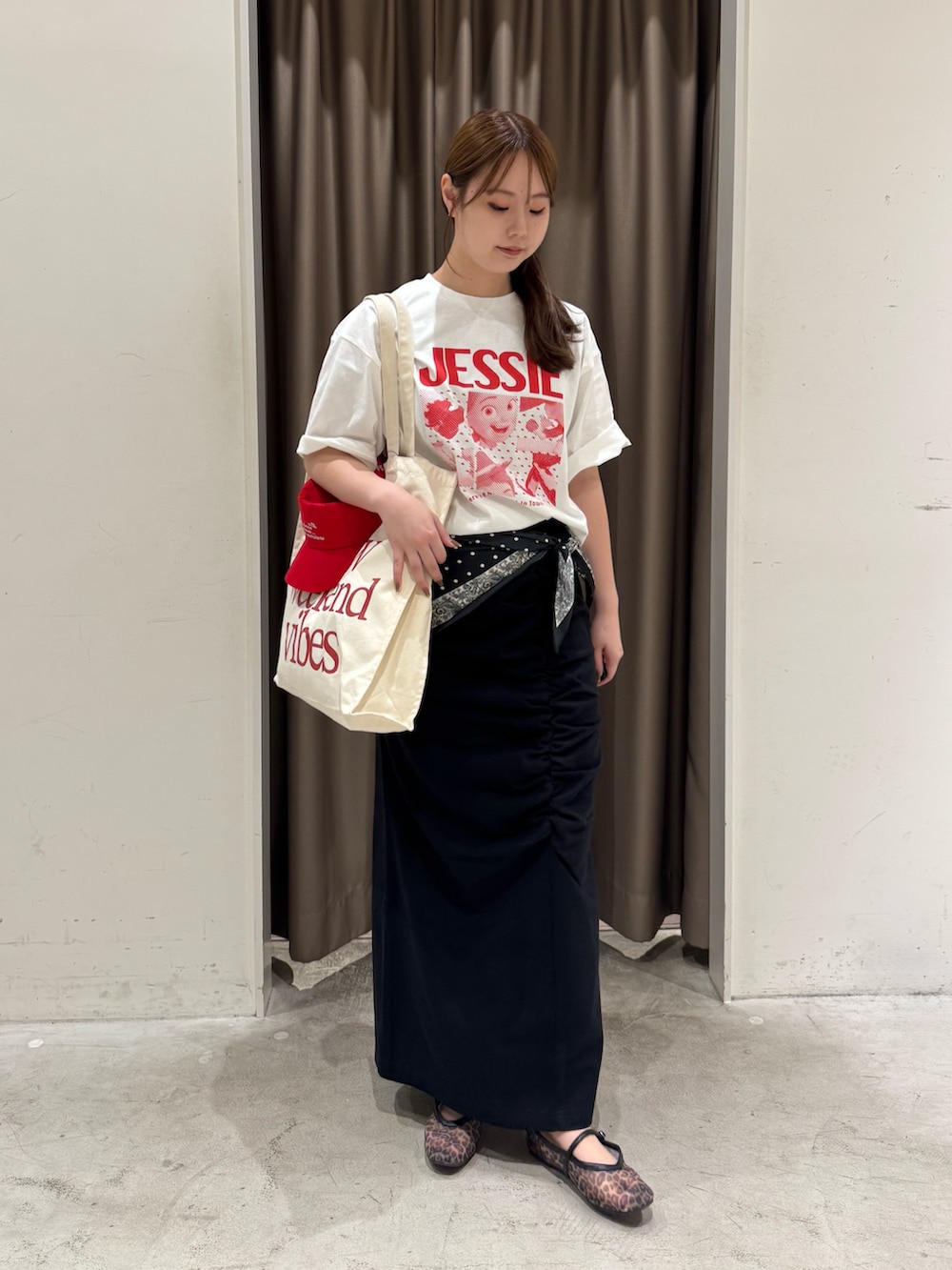 ホワイト系のTシャツ/カットソー、ホワイト系のトートバッグ、ブラック系のスカートを着用したレディースの夏コーディネートの2枚目の写真