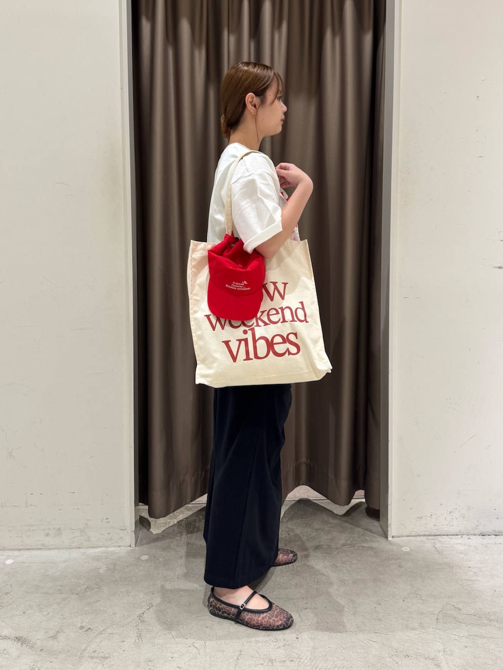 ホワイト系のTシャツ/カットソー、ホワイト系のトートバッグ、ブラック系のスカートを着用したレディースの夏コーディネートの3枚目の写真
