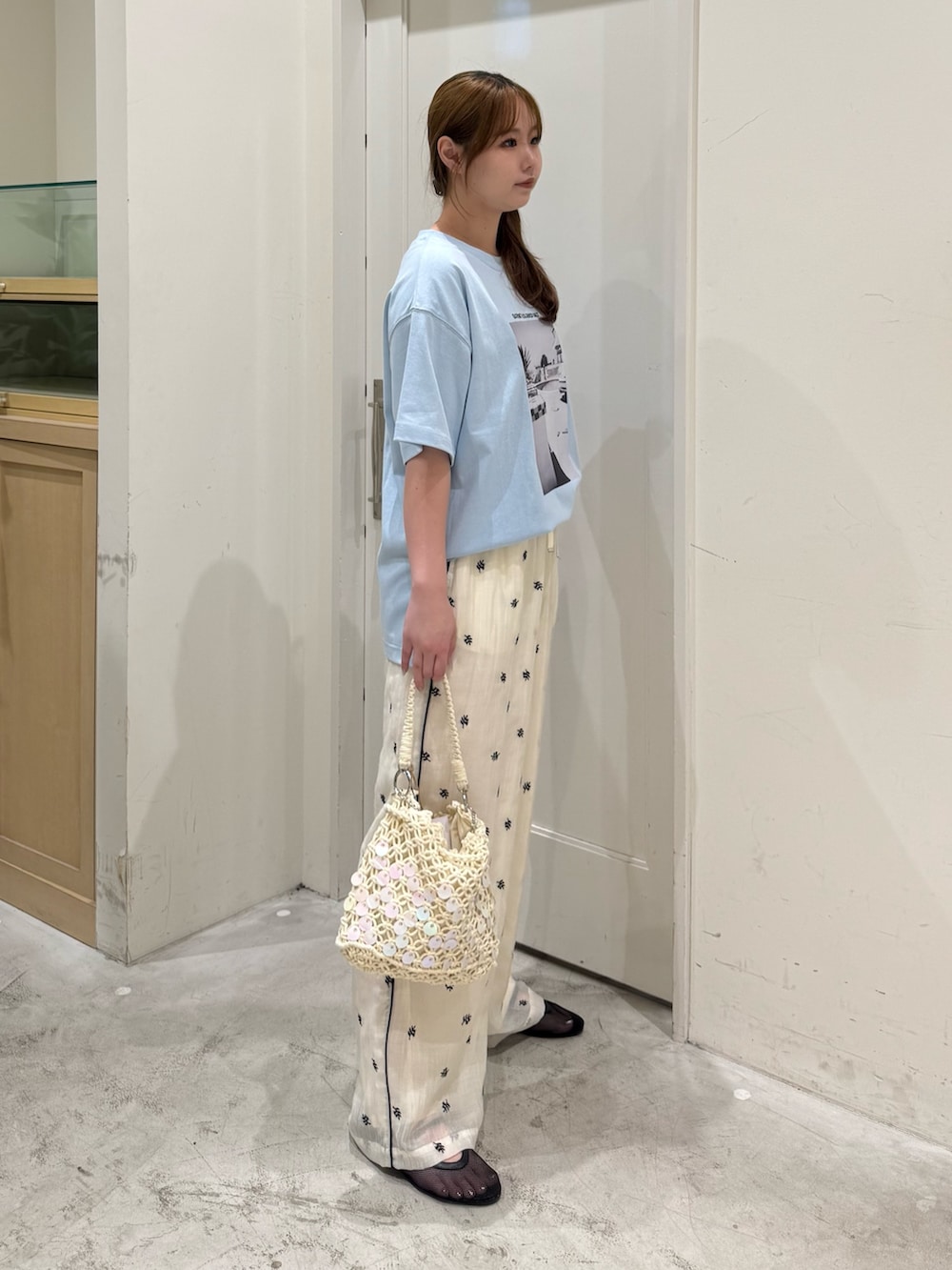 ホワイト系のその他パンツ、ホワイト系のショルダーバッグ、ブラック系のパンプスを着用したレディースの夏コーディネートの4枚目の写真