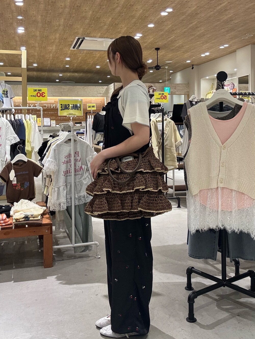ホワイト系のニット/セーター、ブラック系のサロペット/オーバーオール、ブラウン系のトートバッグを着用したレディースの夏コーディネートの4枚目の写真