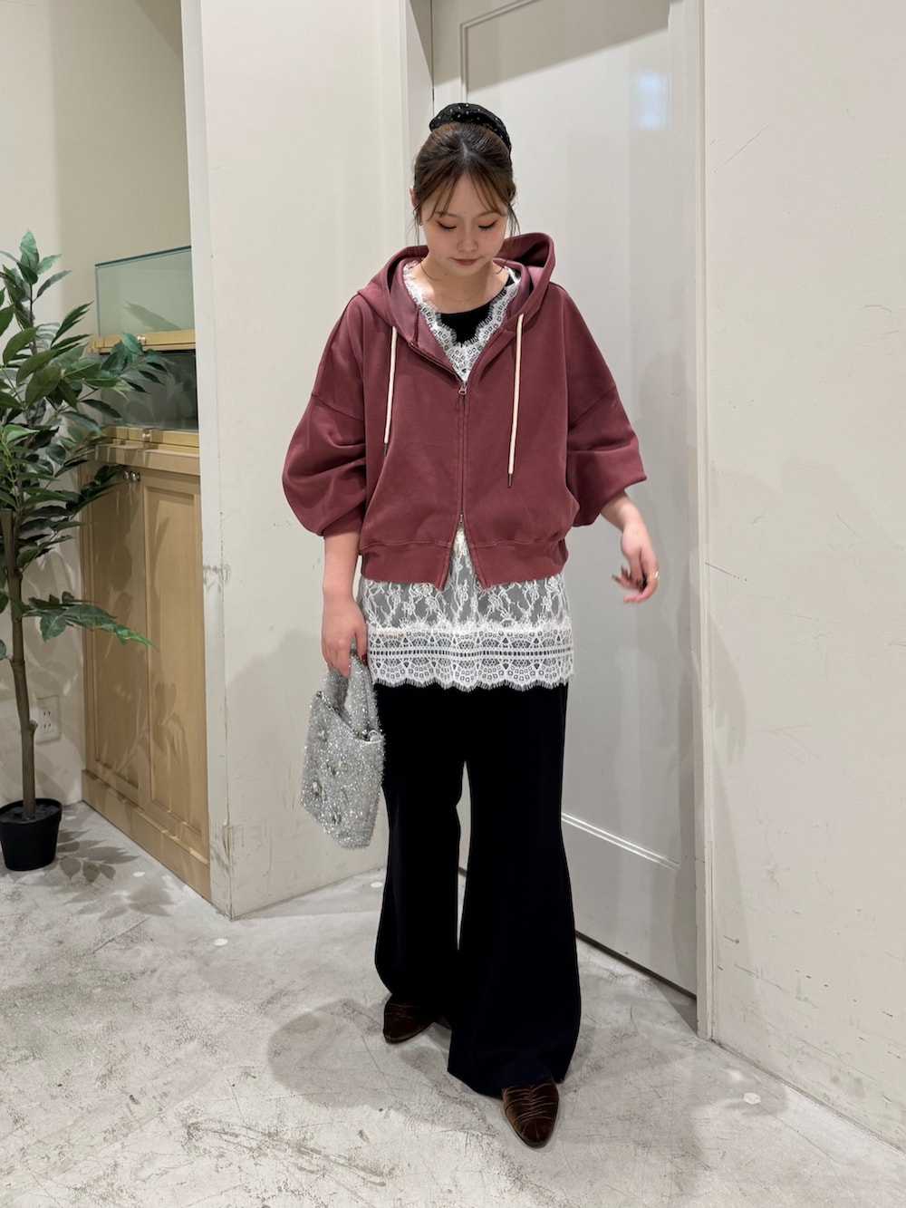 レッド系のパーカー、ホワイト系のチュニック、ブラック系のタンクトップを着用したレディースの秋コーディネートの7枚目の写真