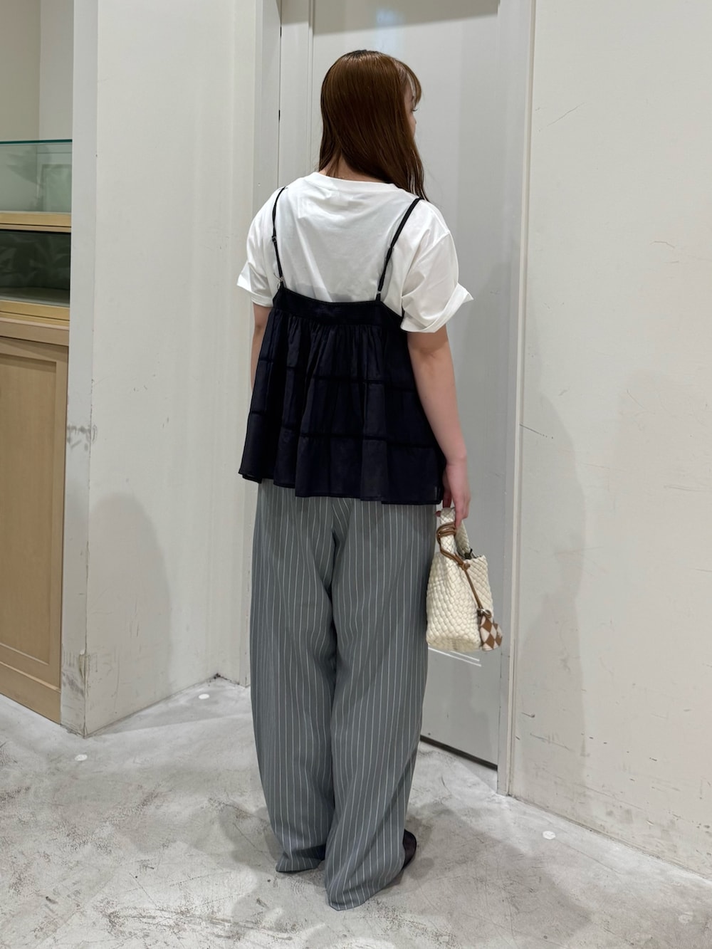 グレー系のその他パンツ、ホワイト系のショルダーバッグ、ブラック系のシャツ/ブラウスを着用したレディースの夏コーディネートの6枚目の写真