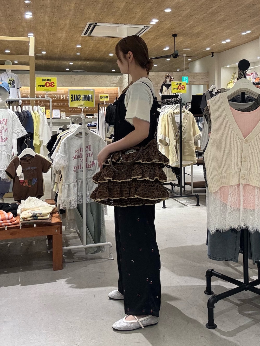 ホワイト系のニット/セーター、ブラック系のサロペット/オーバーオール、ブラウン系のトートバッグを着用したレディースの夏コーディネートの3枚目の写真