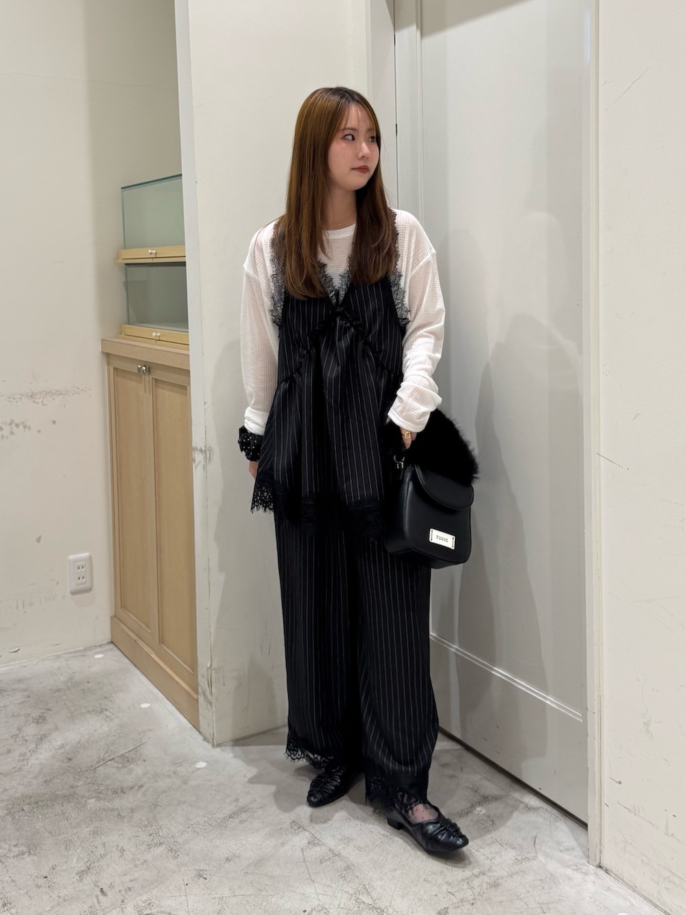 ブラック系のチュニック、ホワイト系のTシャツ/カットソー、ブラック系のショルダーバッグを着用したレディースの秋コーディネートの2枚目の写真