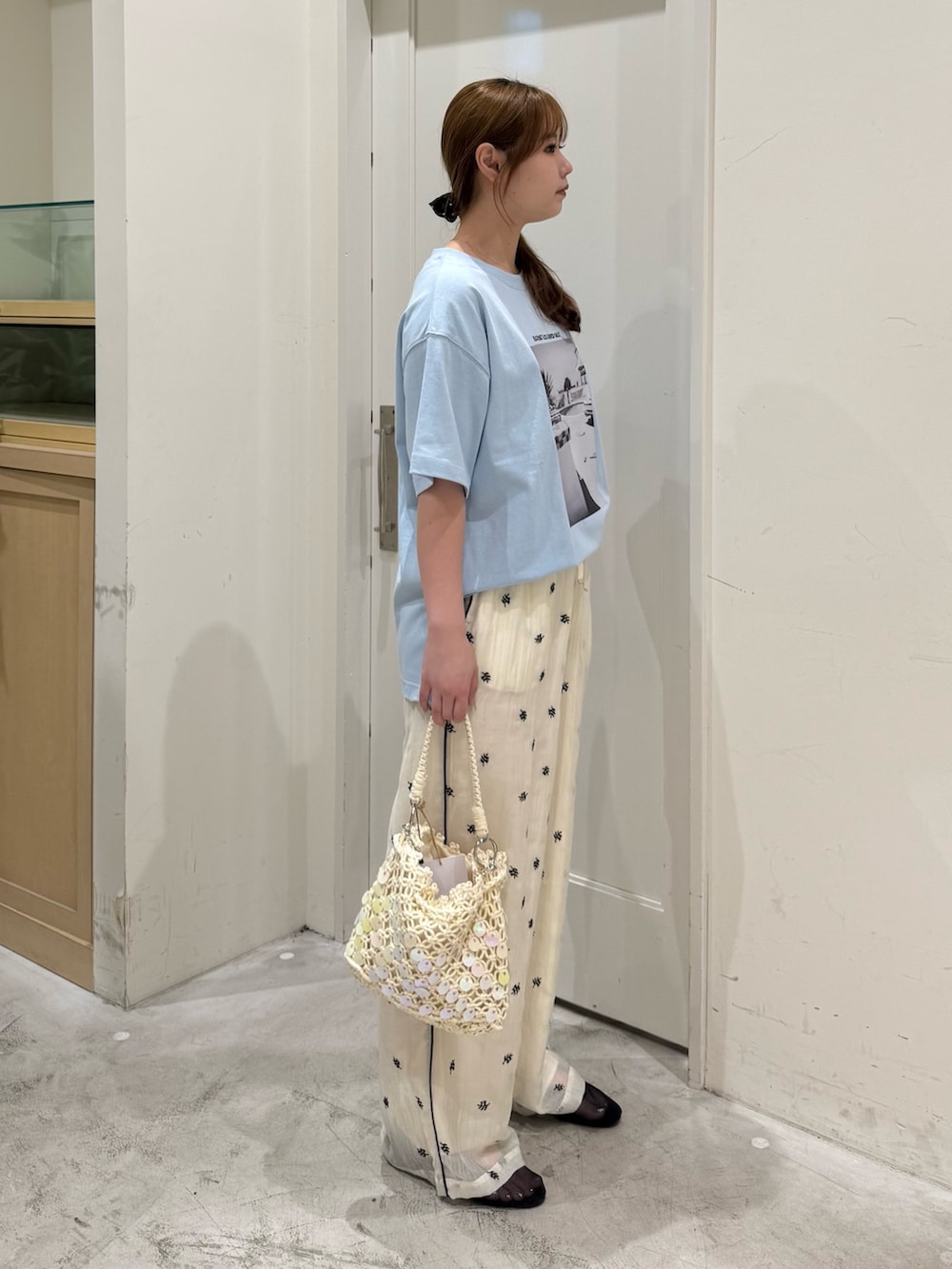 ホワイト系のその他パンツ、ホワイト系のショルダーバッグ、ブラック系のパンプスを着用したレディースの夏コーディネートの5枚目の写真