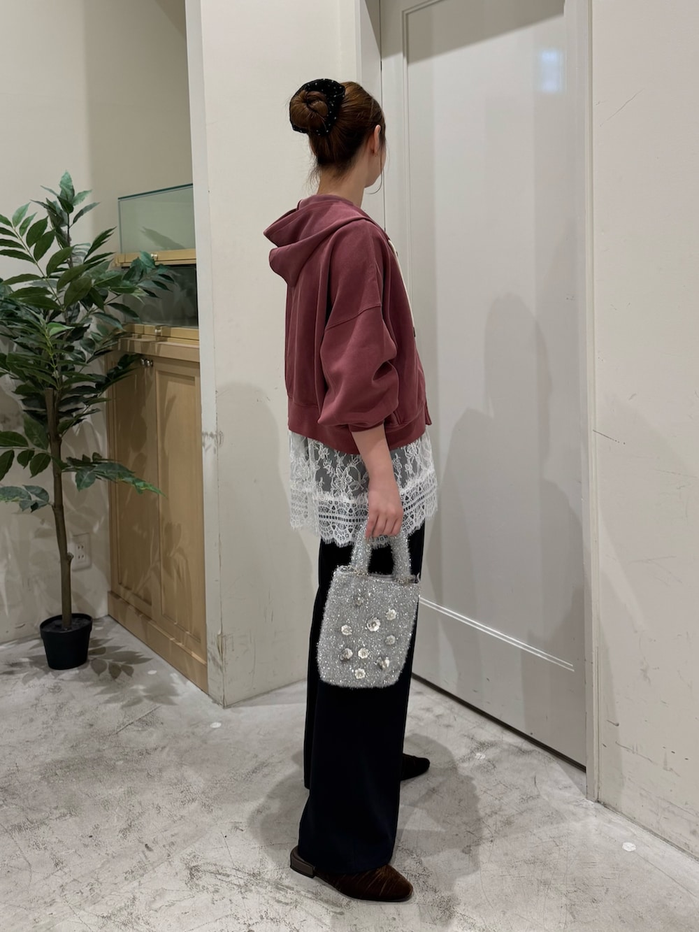 レッド系のパーカー、ホワイト系のチュニック、ブラック系のタンクトップを着用したレディースの秋コーディネートの6枚目の写真
