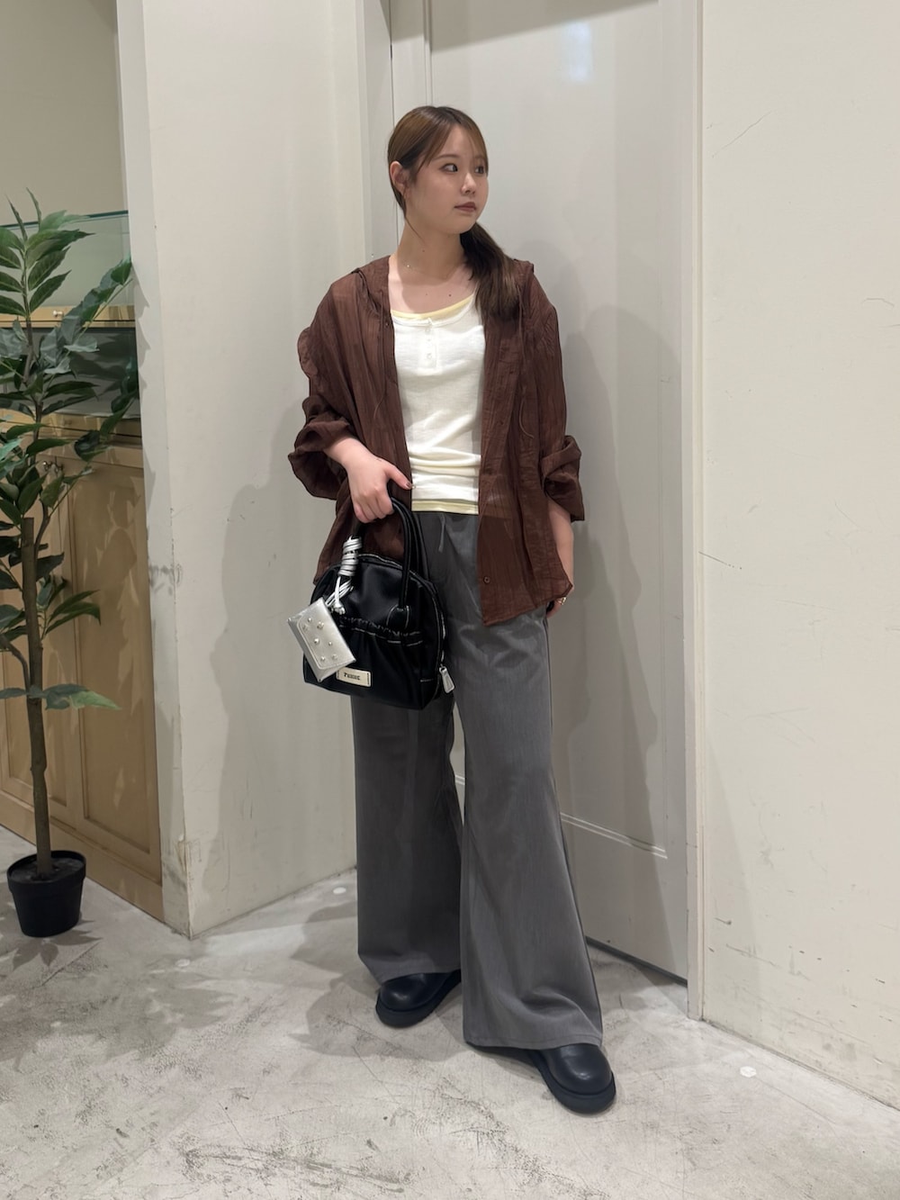ブラウン系のシャツ/ブラウス、ブラック系のショルダーバッグ、ホワイト系のタンクトップを着用したレディースの夏コーディネートの3枚目の写真