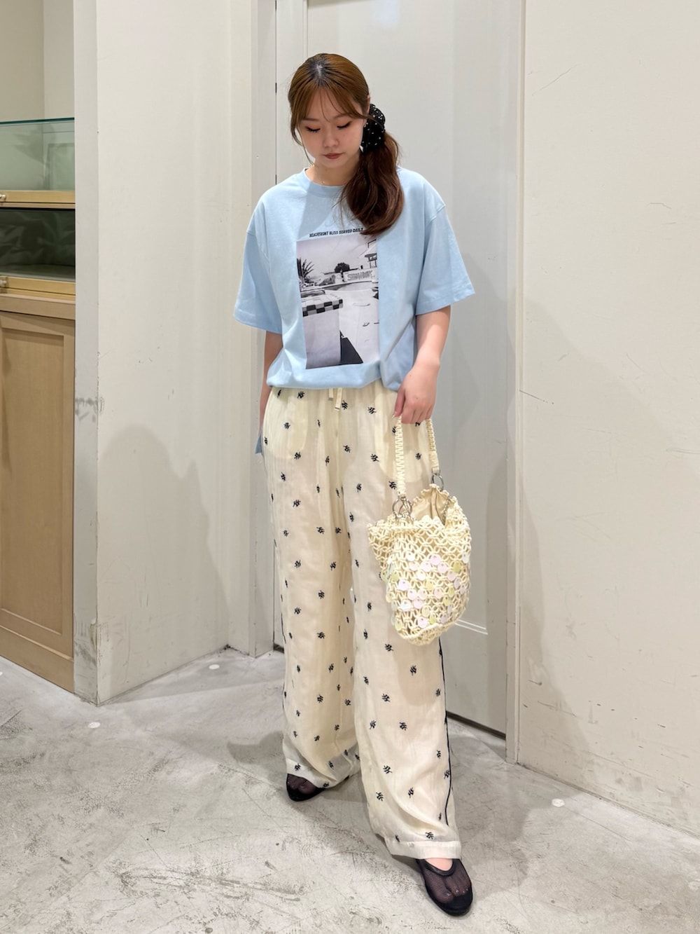 ホワイト系のその他パンツ、ホワイト系のショルダーバッグ、ブラック系のパンプスを着用したレディースの夏コーディネートの3枚目の写真