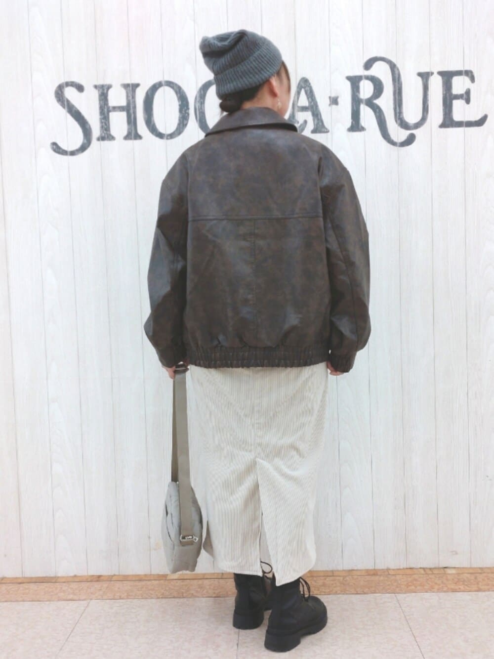 ブラウン系のブルゾン、ベージュ系のスカート、グレー系のTシャツ/カットソーを着用したレディースの冬コーディネートの3枚目の写真