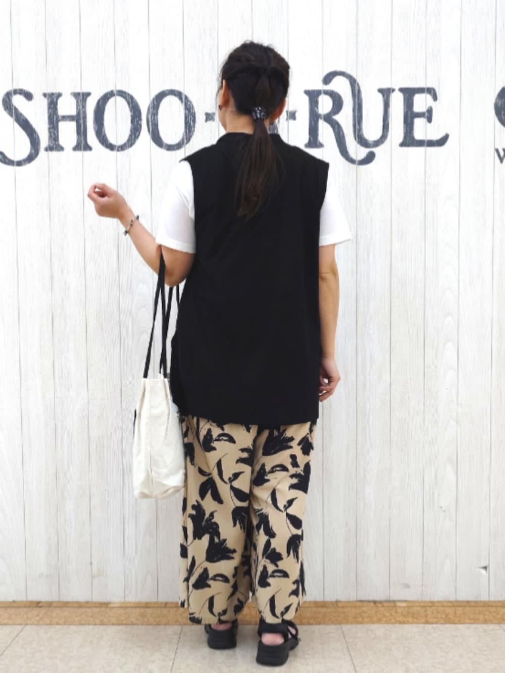 ブラック系のトートバッグ、ベージュ系のその他パンツ、ブラック系のサンダルを着用したレディースの秋コーディネートの3枚目の写真