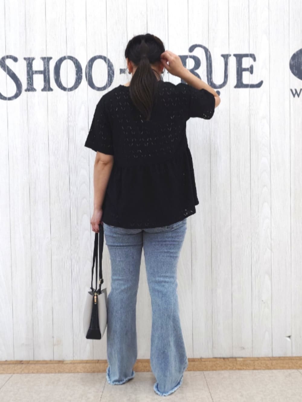 ブラック系のTシャツ/カットソー、ブルー系のデニムパンツ、ブラック系のショルダーバッグを着用したレディースの秋コーディネートの3枚目の写真