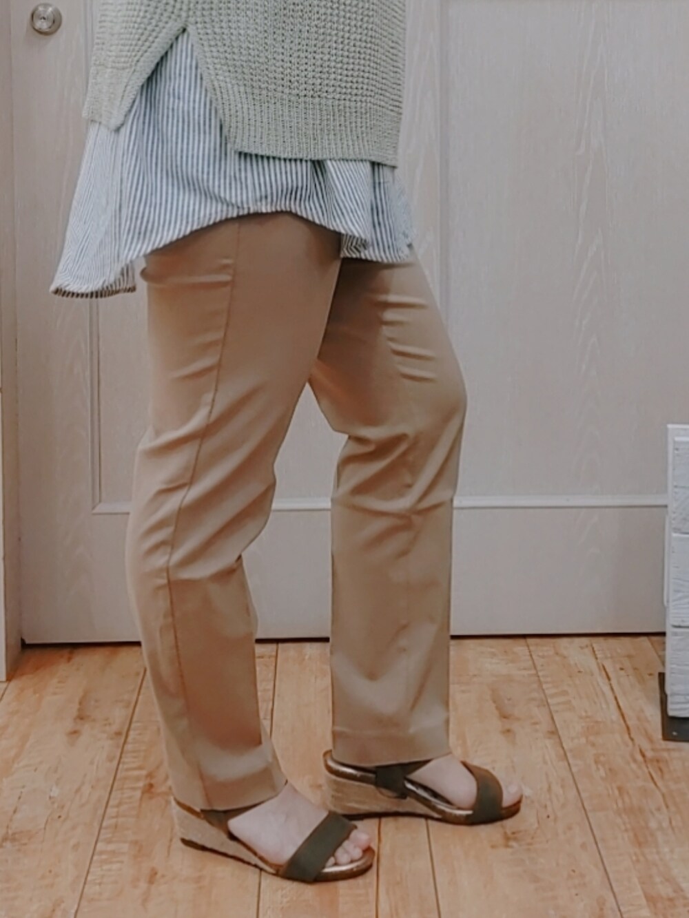 グリーン系のベスト、ブラック系のシャツ/ブラウス、ブラウン系のハンドバッグを着用したレディースの春コーディネートの2枚目の写真